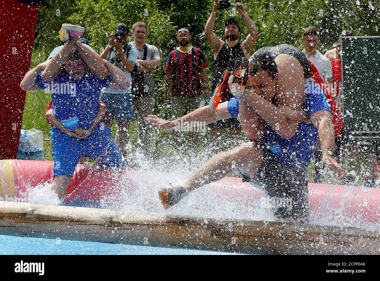 Men carry their wives over a water obstacle while racing in the Wife Carrying competititon to mark the City Day in Krasnoyarsk, Siberia, Russia, June 10, 2017. Picture taken June 10, 2017. REUTERS/Ilya Naymushin Stock Photo