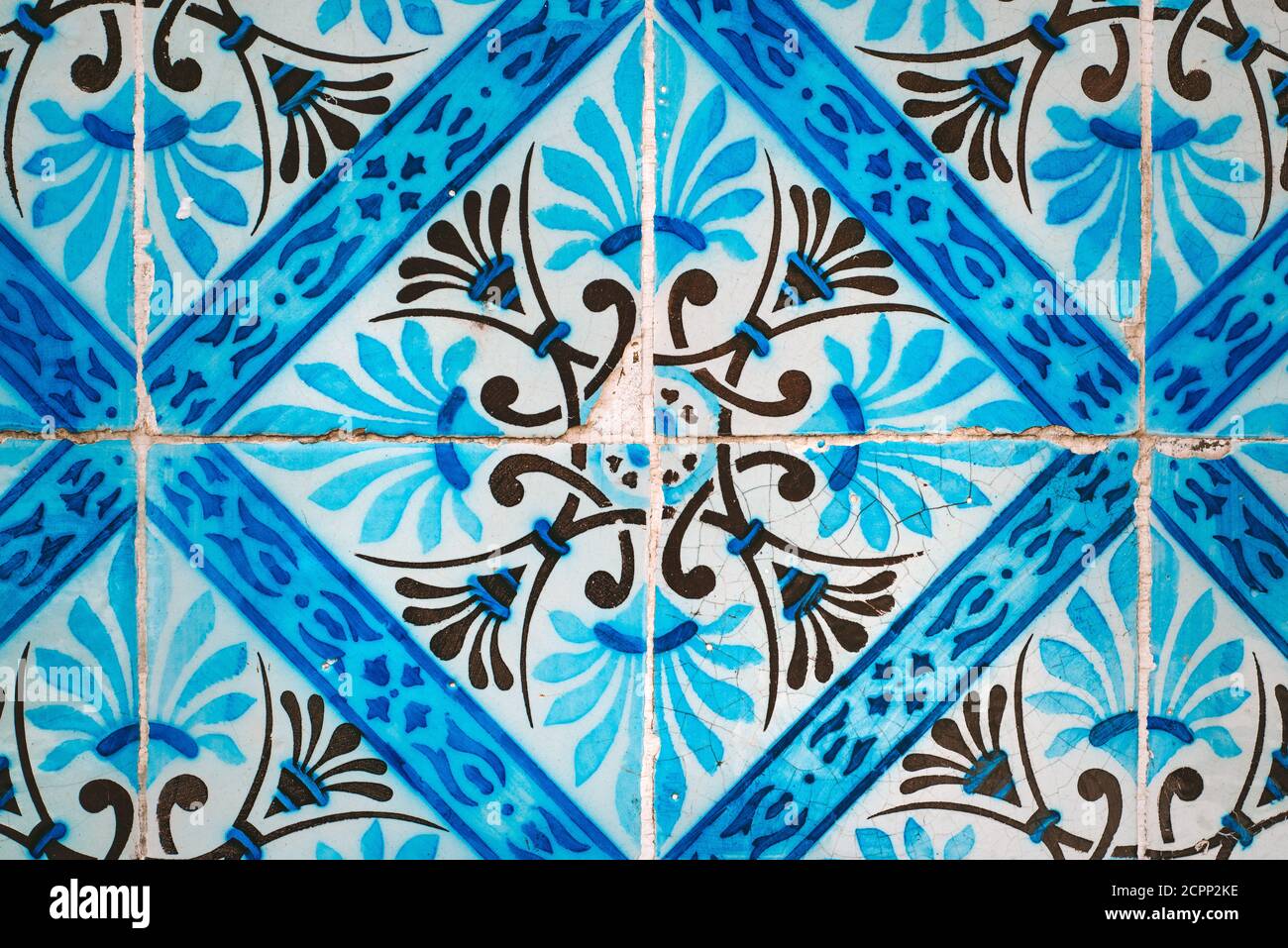 Old broken colourful vintage ceramic tiles wall background from Portugal. Blue, white and black pattern. Stock Photo