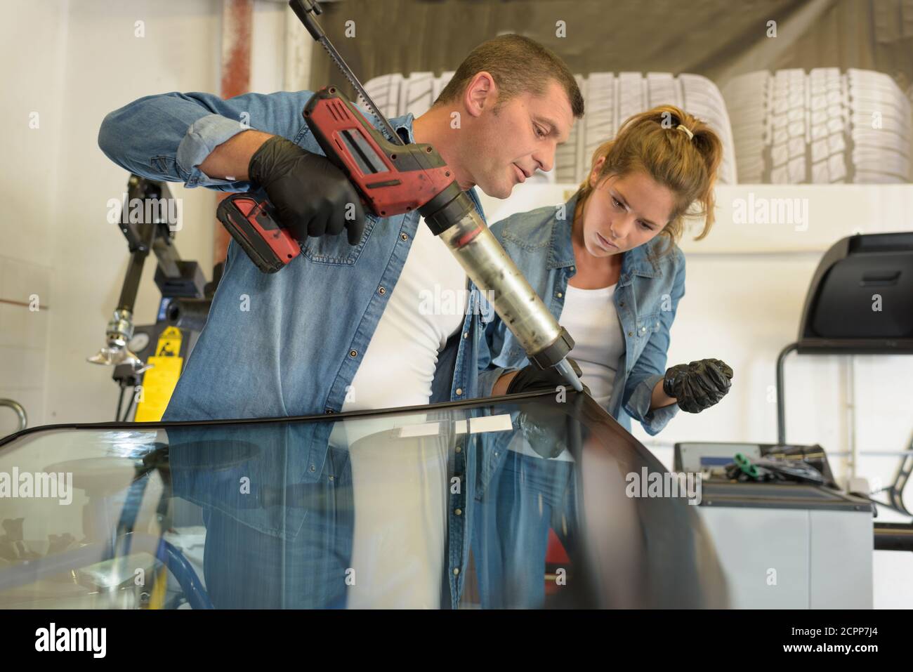glazier using tools repairing fix crack broken windshield Stock Photo
