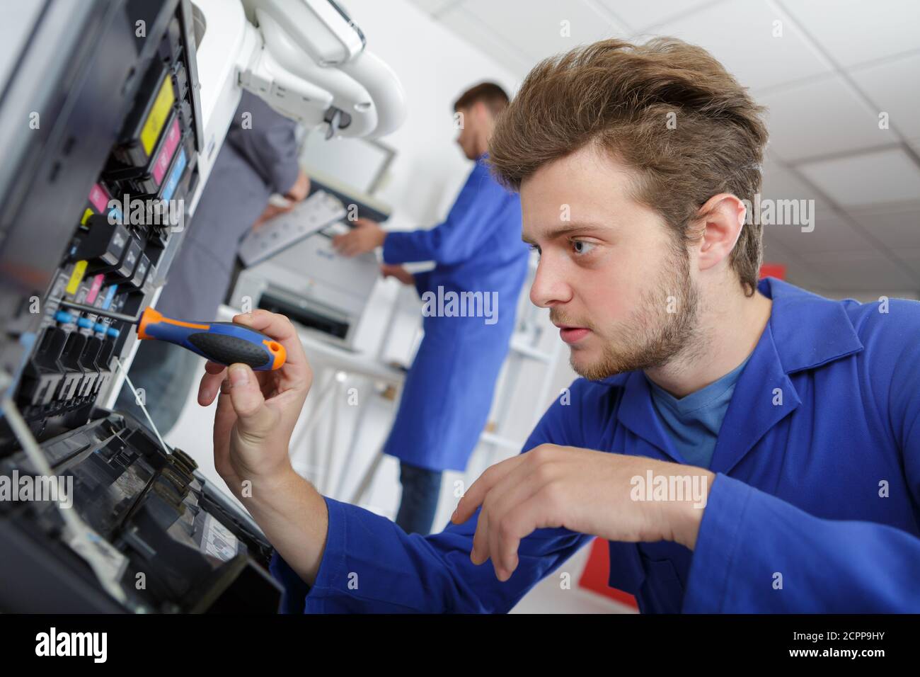 technician using a tablet to fix a printer Stock Photo
