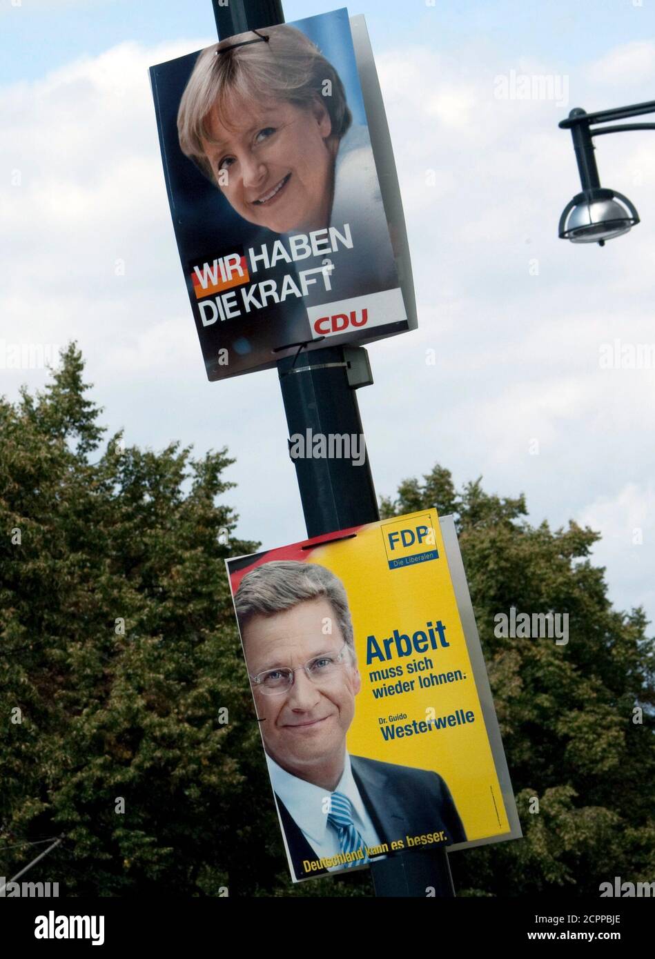 Election posters of the conservative Christian Democratic Union (CDU) party showing German Chancellor Angela Merkel (top) and of the liberal FDP party showing its leader Guido Westerwelle are seen in central Berlin August 18, 2009. Germany will vote in a general election September 27.  REUTERS/Thomas Peter  (GERMANY POLITICS ELECTIONS) Stock Photo