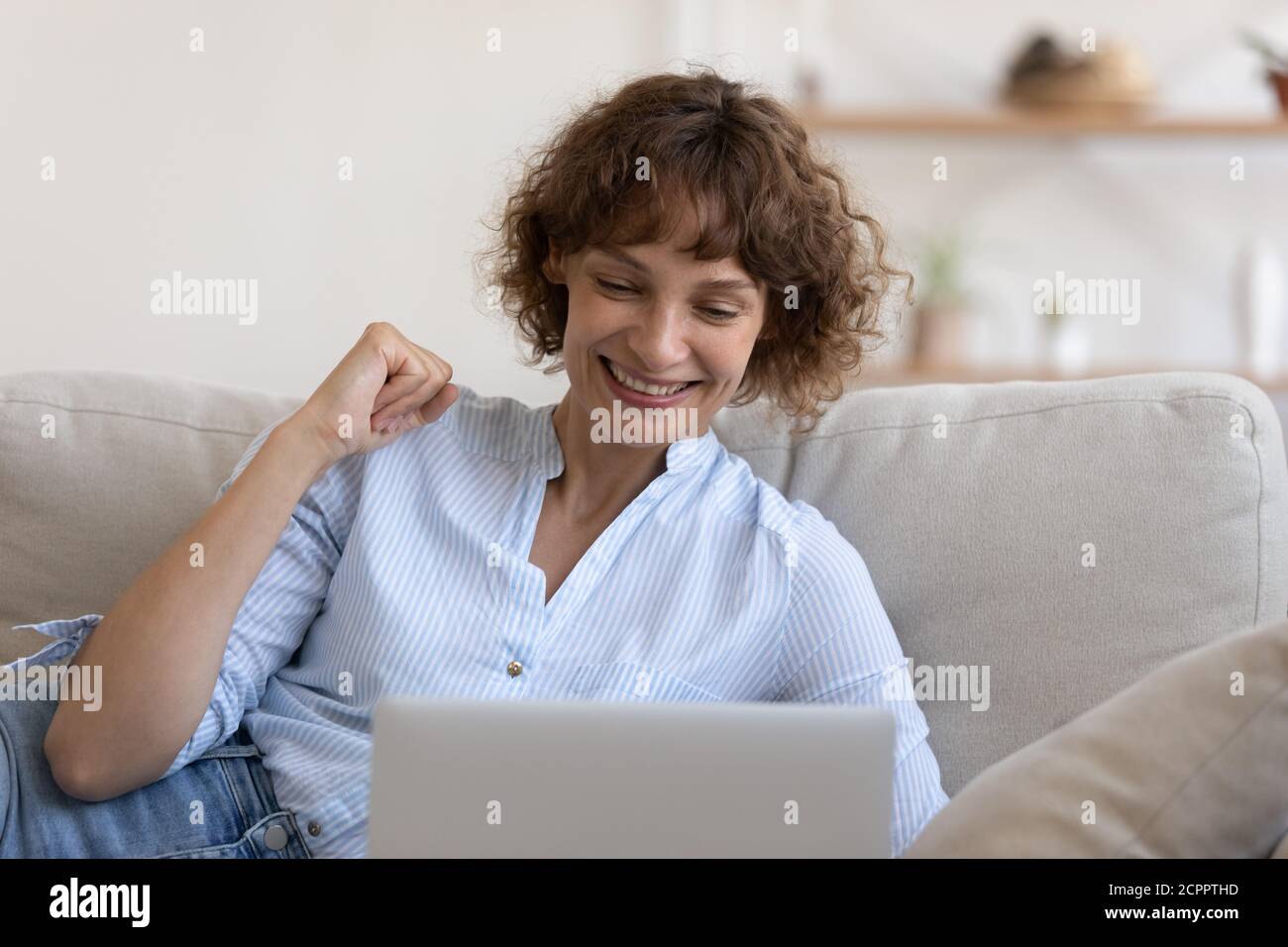 Happy young woman celebrate online win on laptop Stock Photo