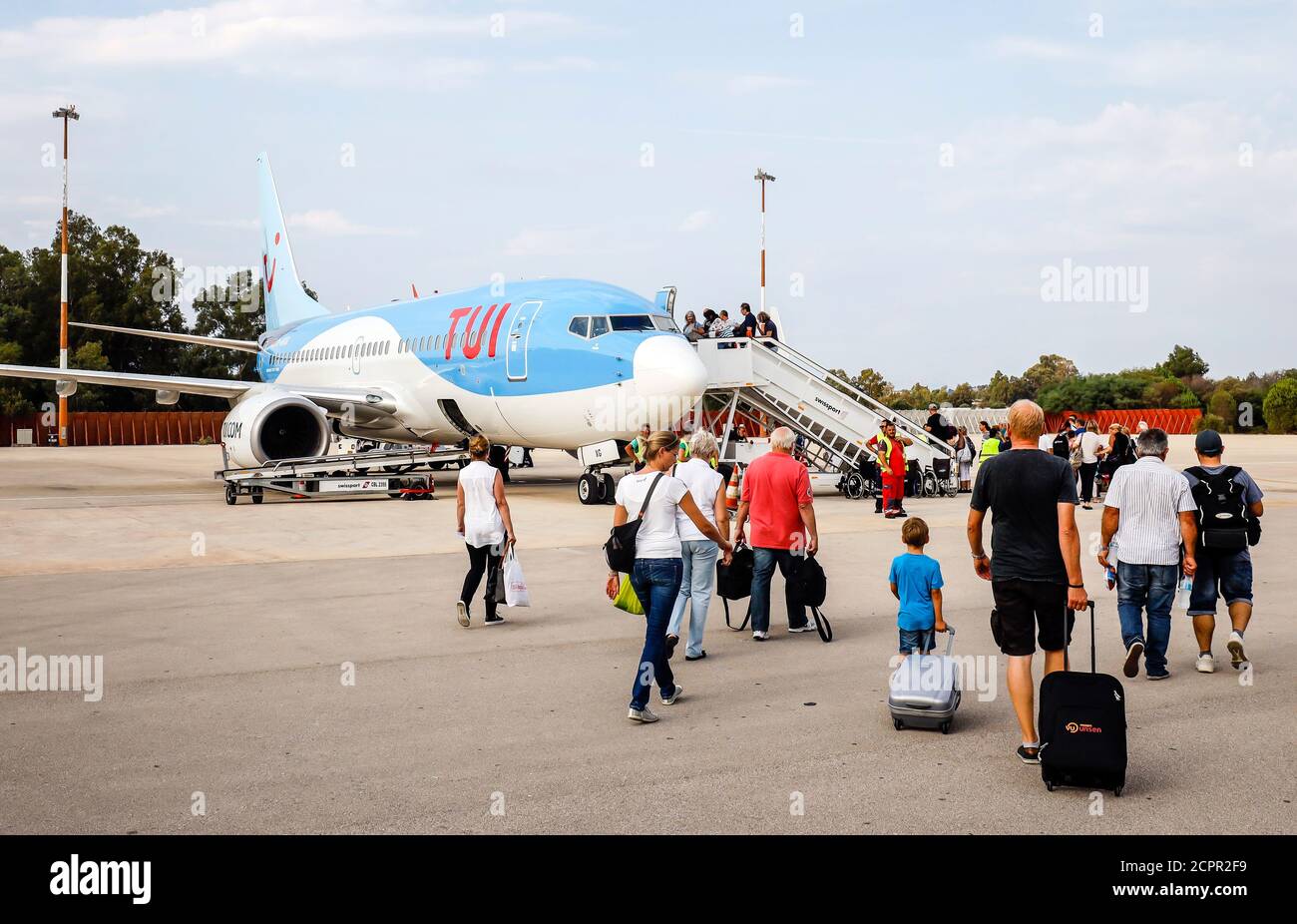 Patras, Peloponnese, Greece - Vacationers with suitcases on the way to the TUI plane, Araxos GPA airport. Stock Photo