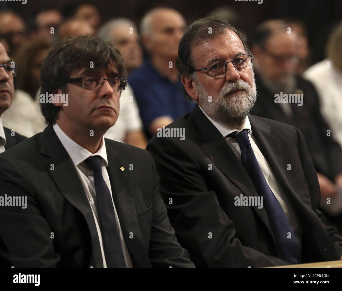 President of the Generalitat of Catalonia Carles Puigdemont and Spanish Prime Minister Mariano Rajoy are seen at a High mass celebrated in memory of the victims of the van attack at Las Ramblas earlier this week, at the Basilica of the Sagrada Familia in Barcelona, Spain August 20, 2017. REUTERS/Sergio Barrenechea/Pool Stock Photo