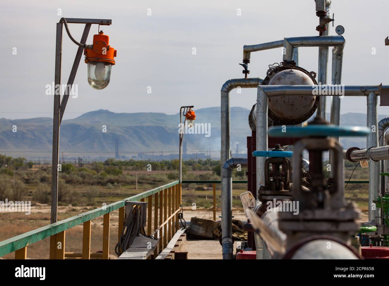 Equipment on oil refinery plant on the industrial, sky and mountain background. Kazakhstan, Taraz city. Stock Photo