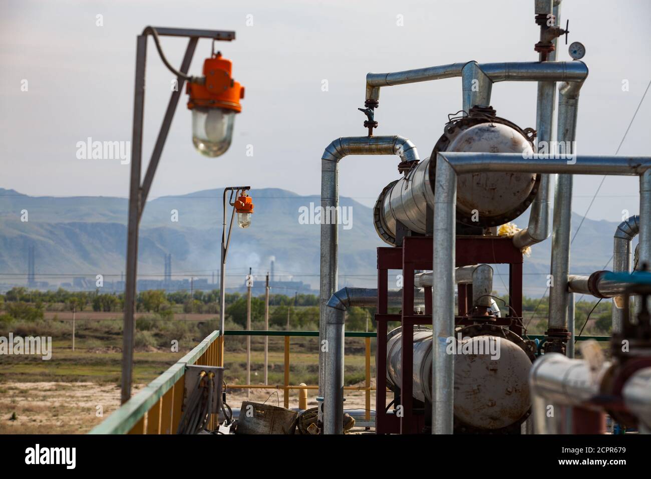 Equipment on oil refinery plant on the sky and mountain background. Kazakhstan, Taraz city. Stock Photo