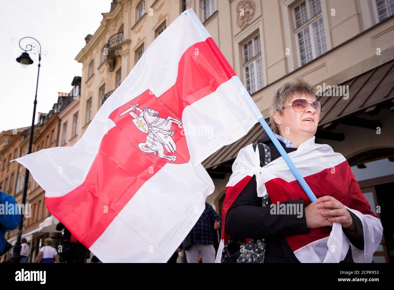 A woman is seen holding the Belarusian White-Red-White flag with the Pogon symbol in Warsaw, Poland on September 19, 2020. Several dozen people, mostl Stock Photo