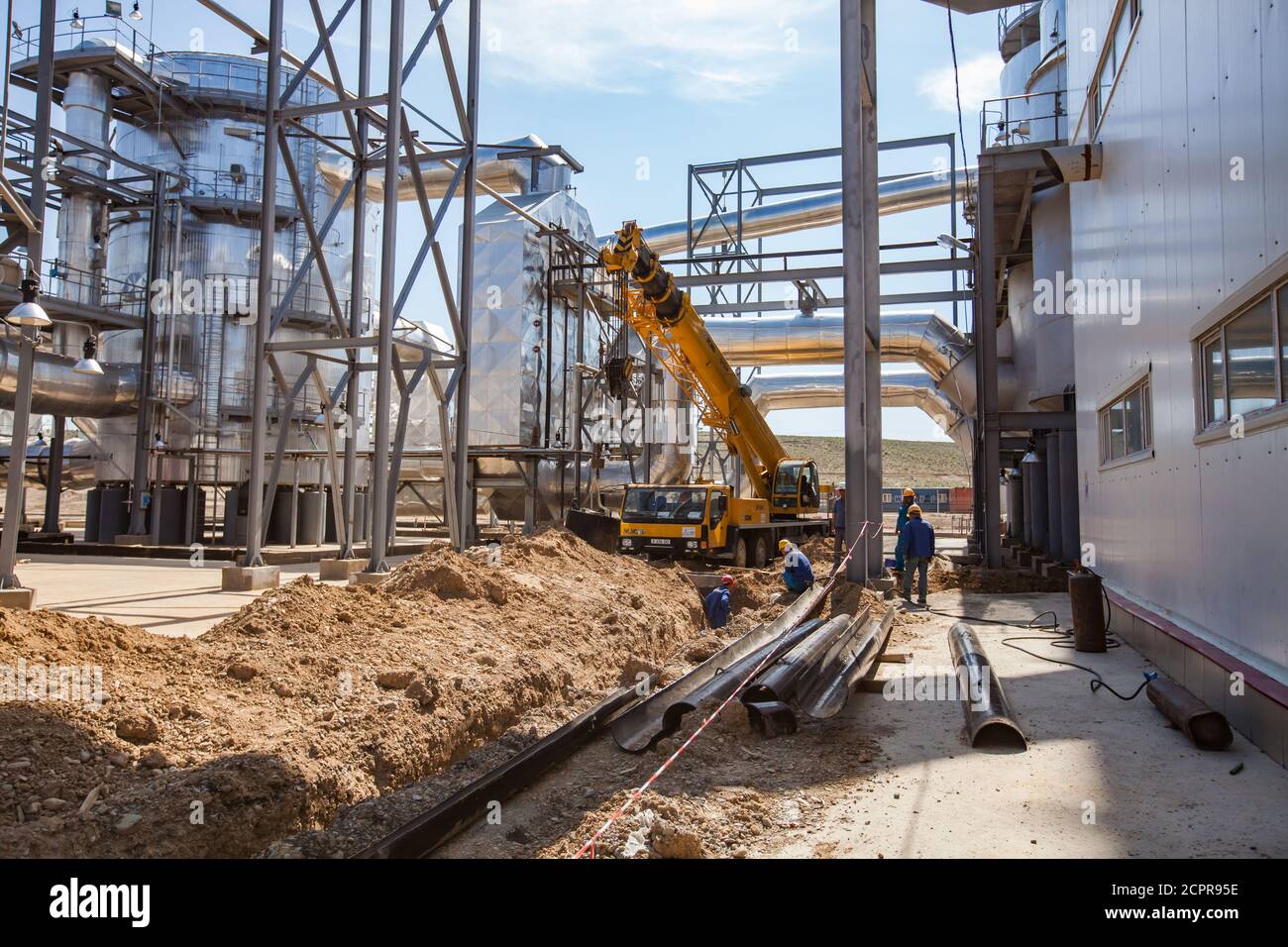 Sulfuric acid plant. Ground works for modernization and renovation with construction workers and mobile crane. Stock Photo
