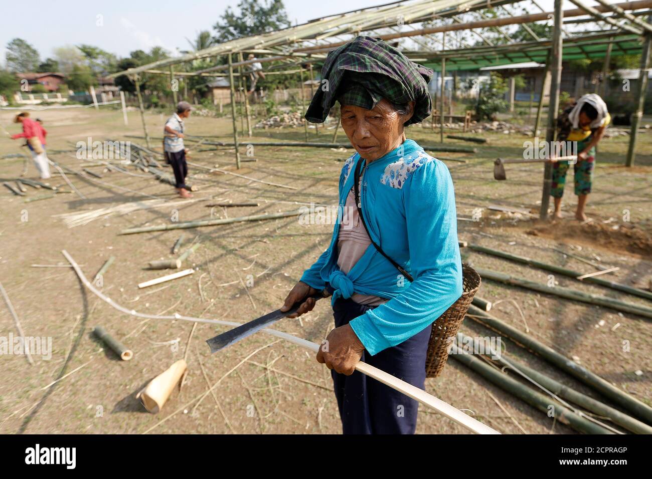 A woman cuts bamboo in a shelter for internally displaced people in Myitkyina, in the countryÕs northern Kachin State, Myanmar May 9, 2018. Picture taken May 9, 2018. REUTERS/Ann Wang Stock Photo