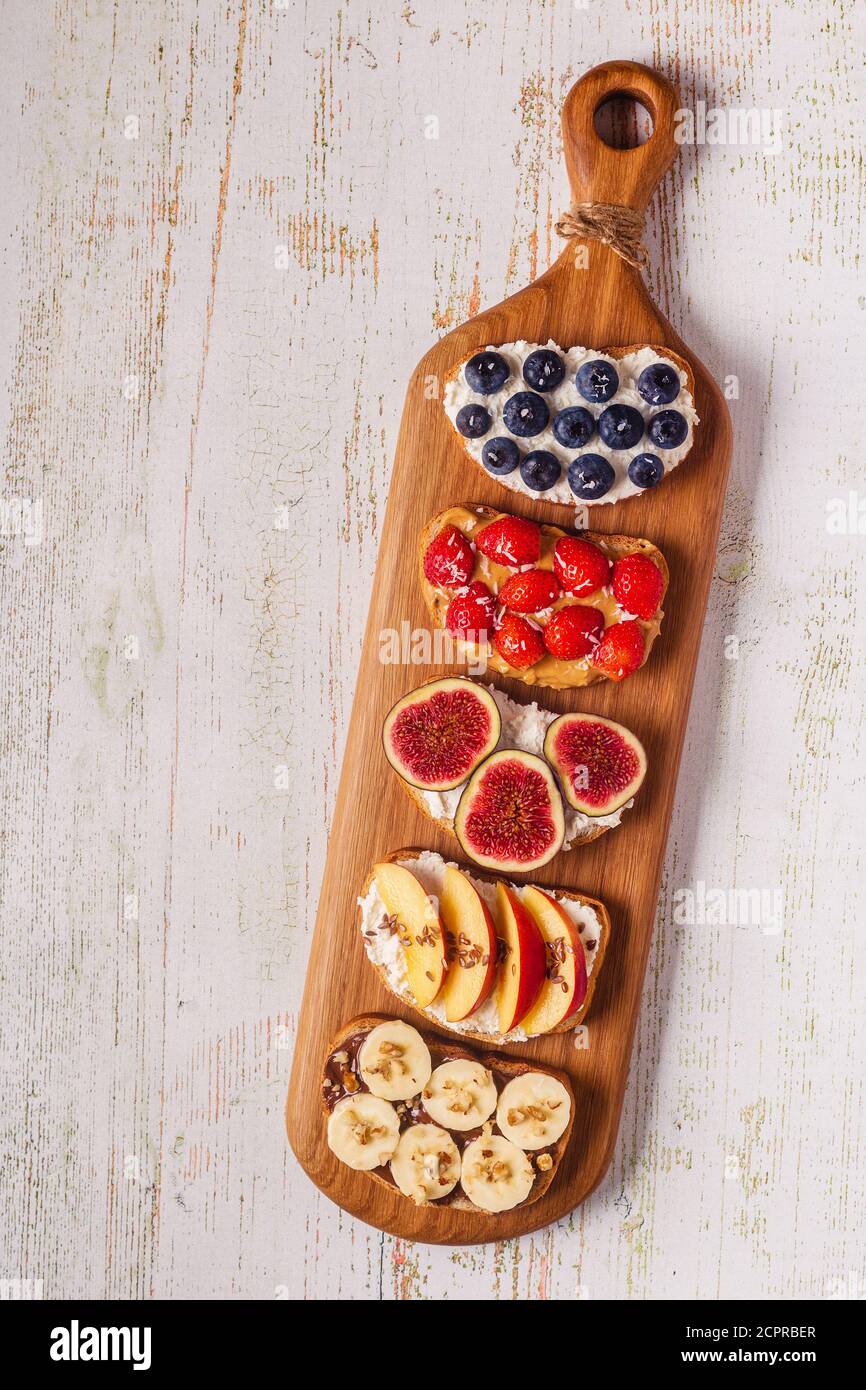 Homemade summer toast with cream cheese, nut butter and fruits and
