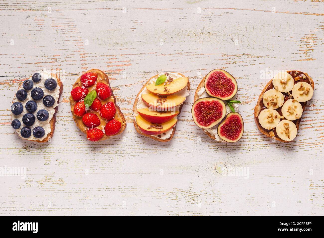 Homemade summer toast with cream cheese, nut butter and fruits and