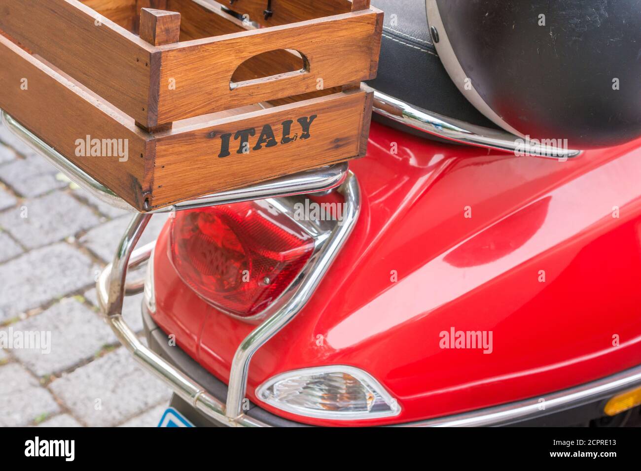 Red scooter with a wooden box on the luggage rack with the inscription Italy Stock Photo