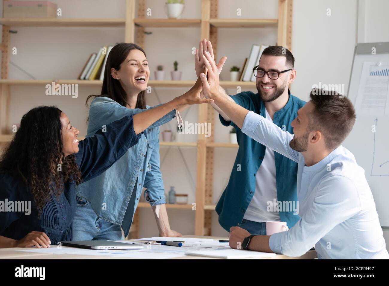 Overjoyed diverse employees giving high five at corporate meeting Stock ...