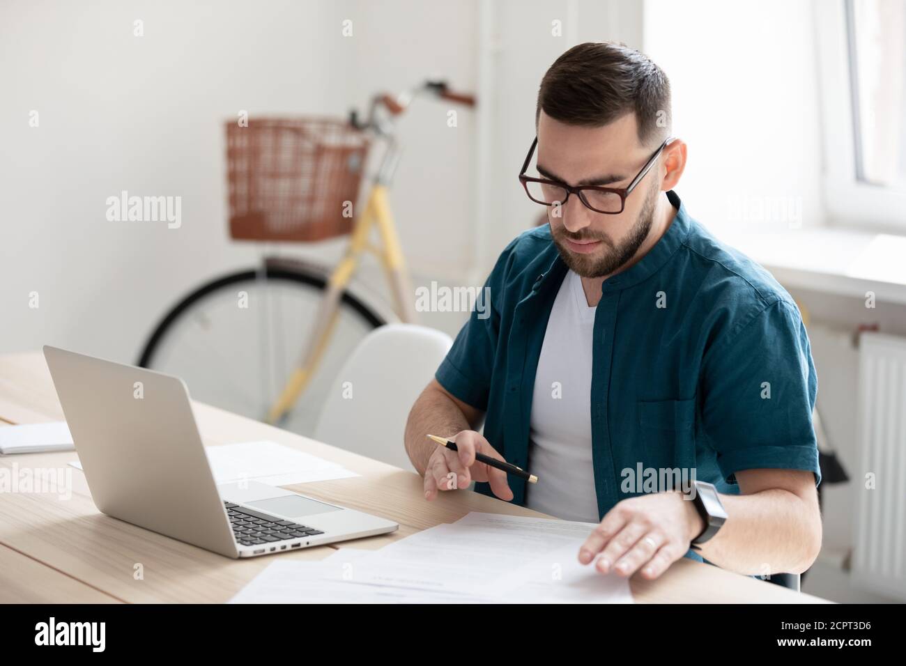 Serious young businessman wearing glasses working with documents Stock Photo