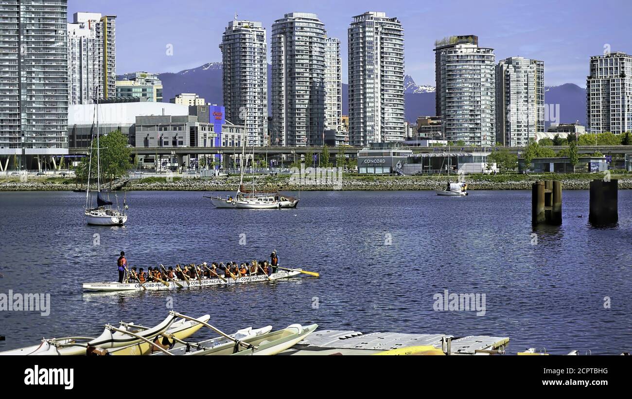 Vancouver, Canada 5-7-2019   A view of Dwontown  Vancover, Canada at the waterway. Showing in forground is a boat full of crewers. Stock Photo