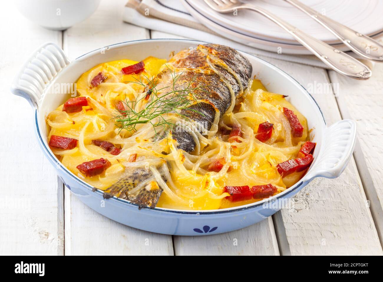 Delicious oven baked trout with potatoes, onions and ham Stock Photo