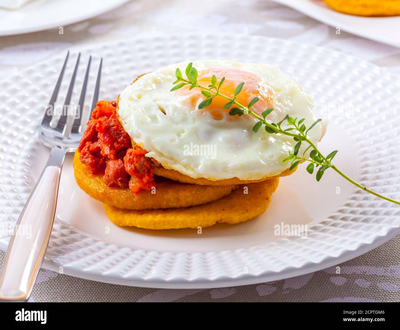 Hearty breakfast pancakes with chorizo and fried egg. Stock Photo