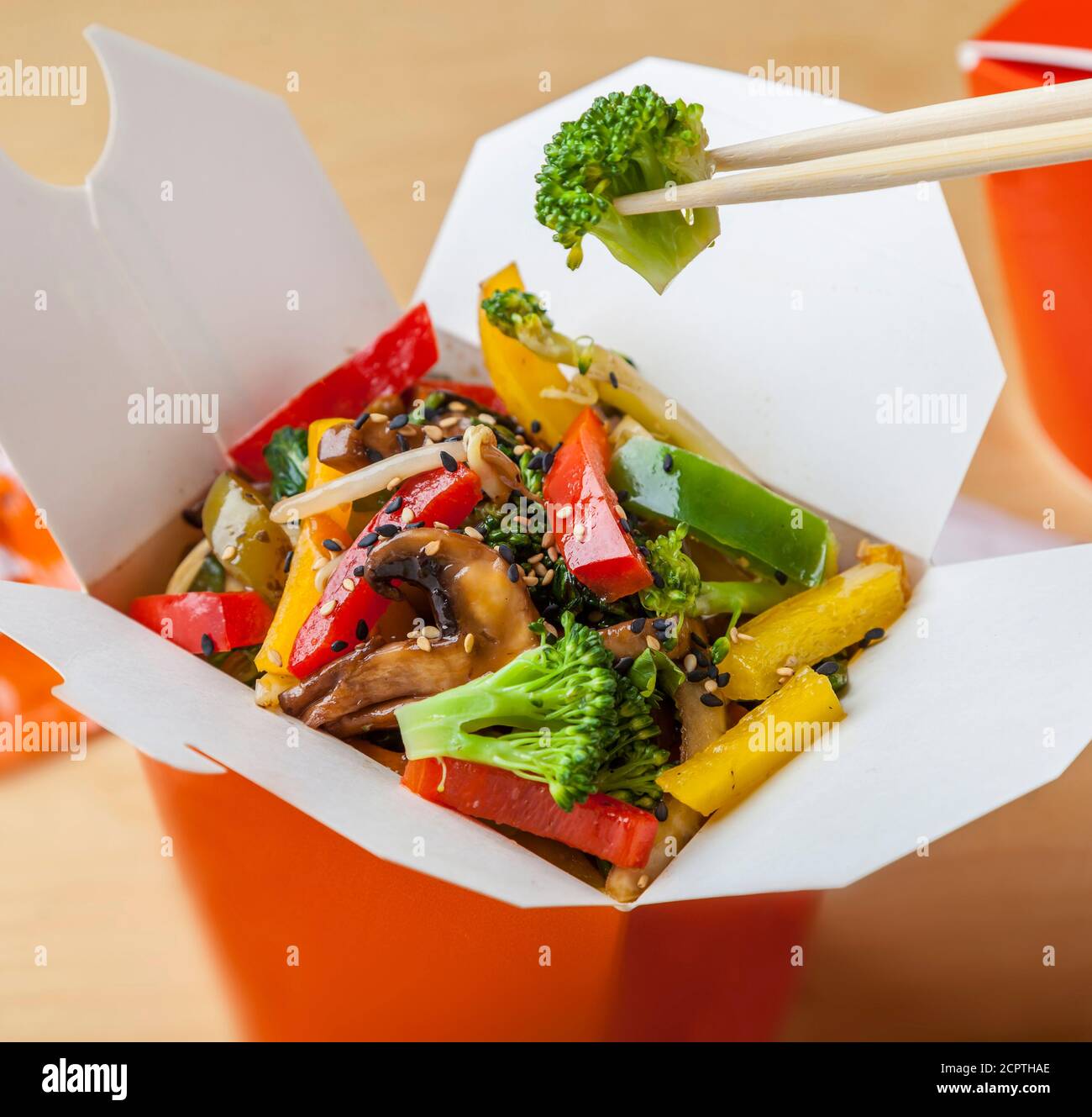 Delicious vegetarian takeaway wok food in a box with chopsticks. Stock Photo