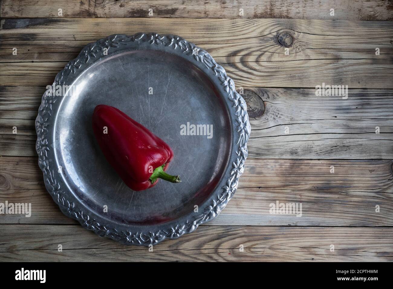 Red pepper on a tray on a wooden background with a copy of the space. Stock Photo