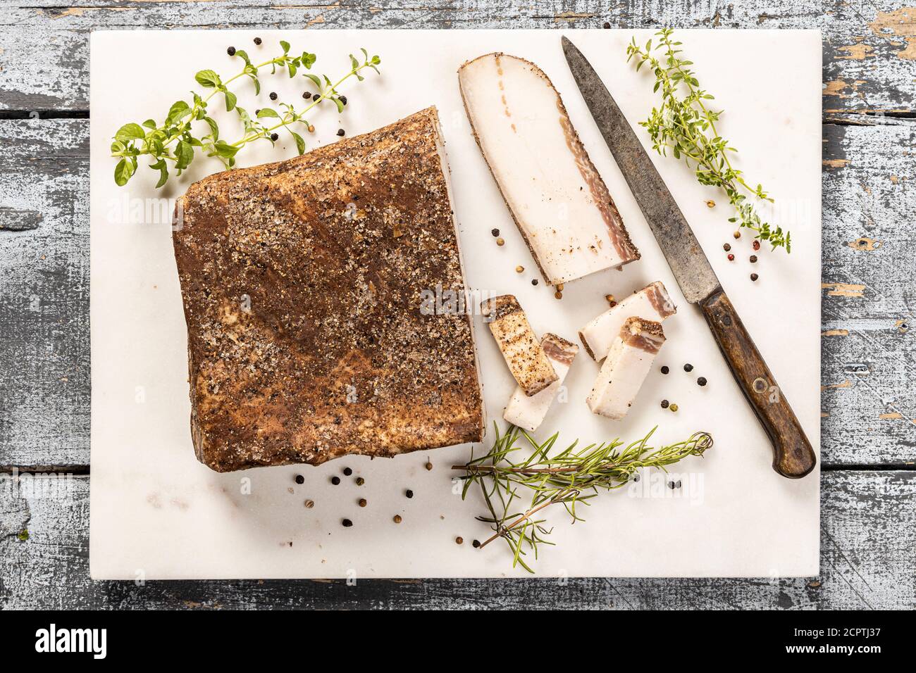 The Tuscan hamlet of Colonnata is a type of salumi made by curing strips of fatback with rosemary and other herbs and spices. Stock Photo