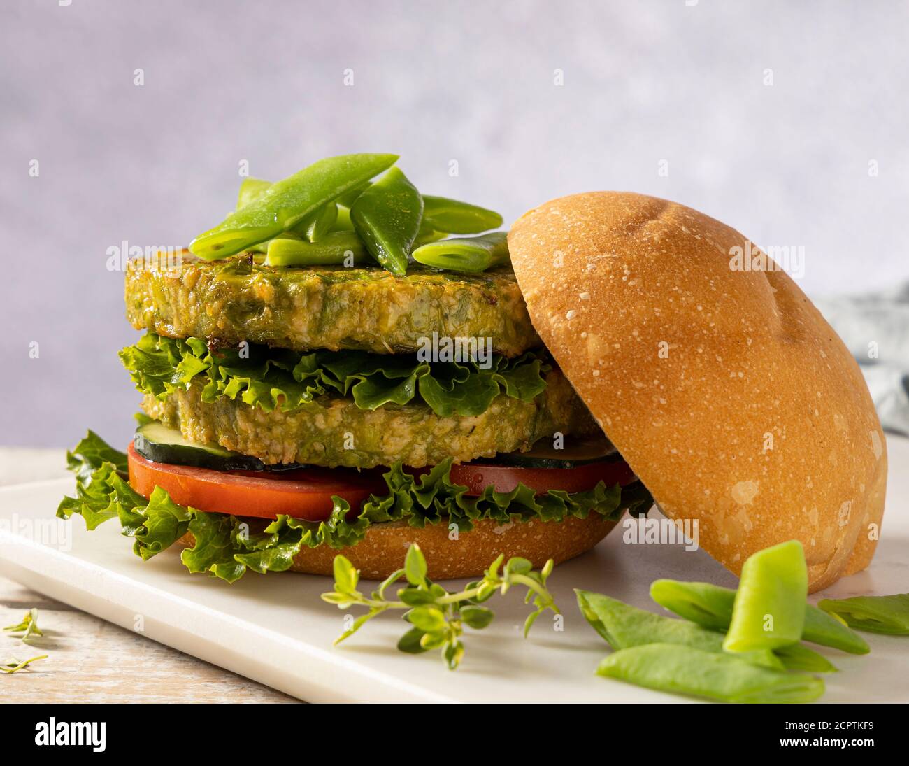 Vegan hamburger made with green beans and chickpeas, served with tomato