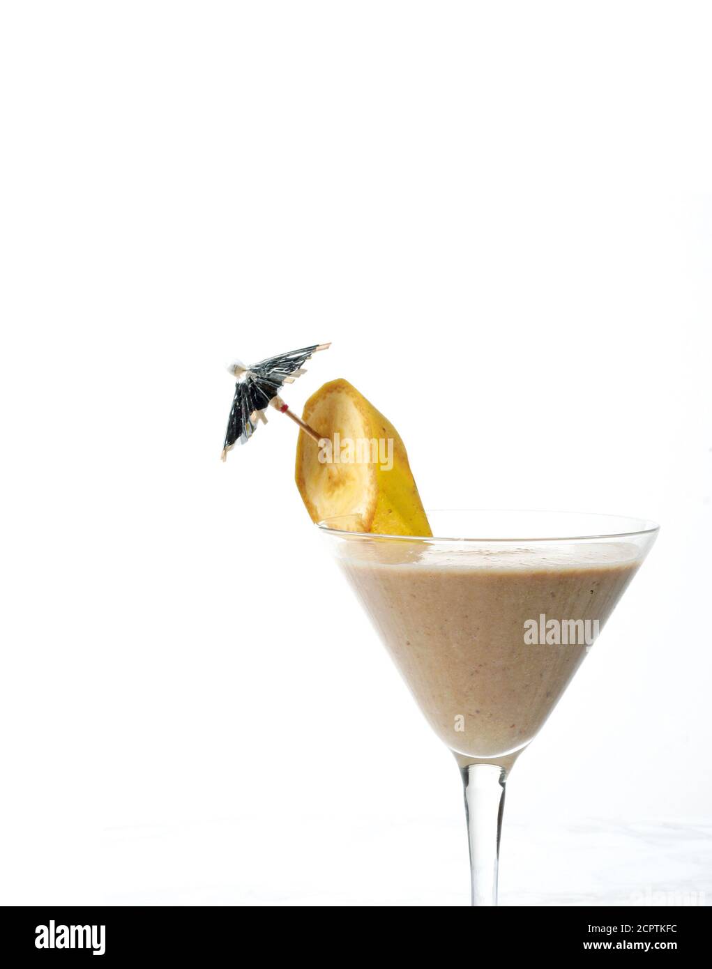Banana smoothie in an elegant glass isolated on white with copy space. Stock Photo