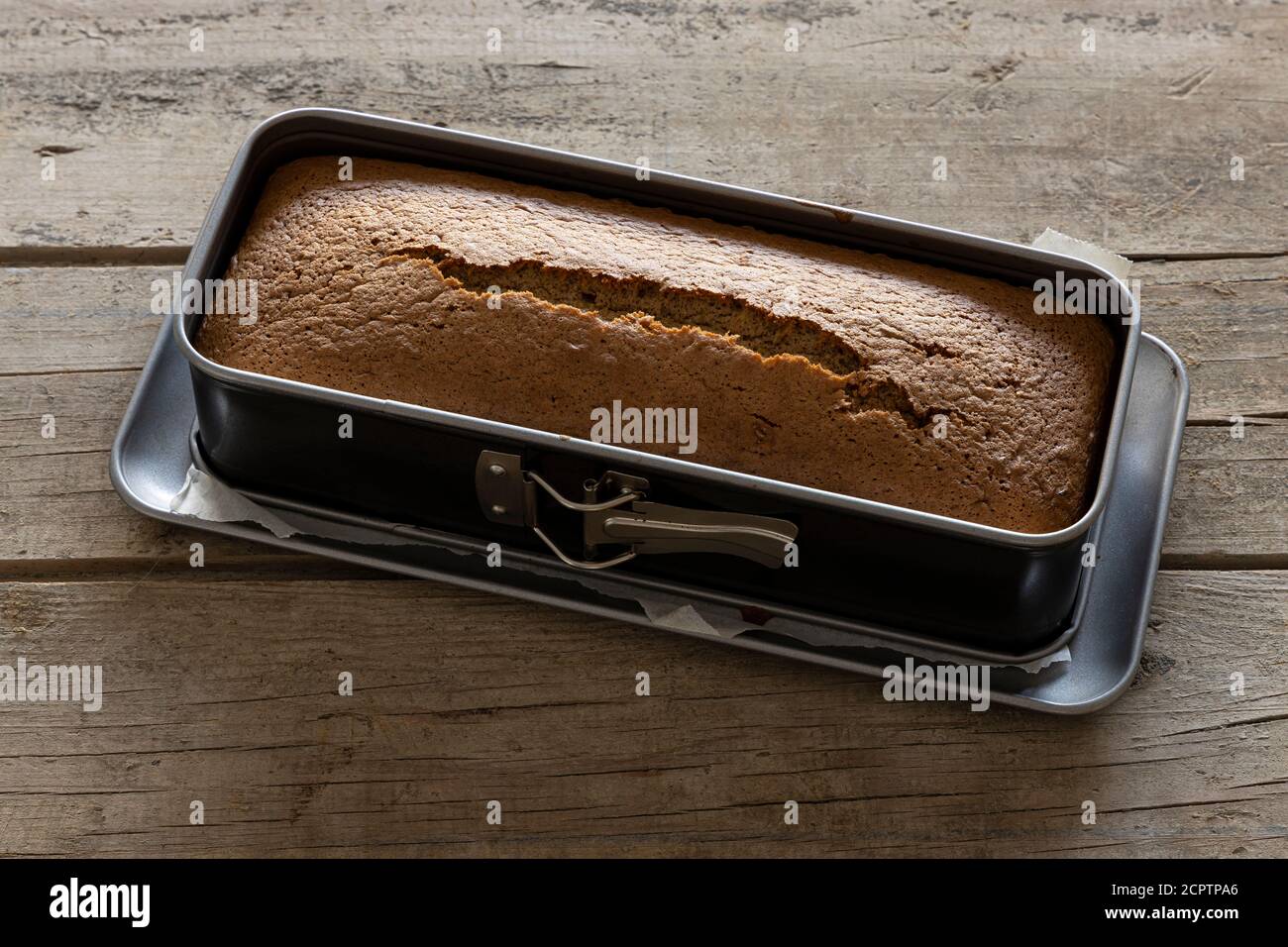 https://c8.alamy.com/comp/2CPTPA6/hot-homemade-cake-straight-from-the-oven-in-a-baking-tin-placed-on-a-vintage-wooden-table-2CPTPA6.jpg