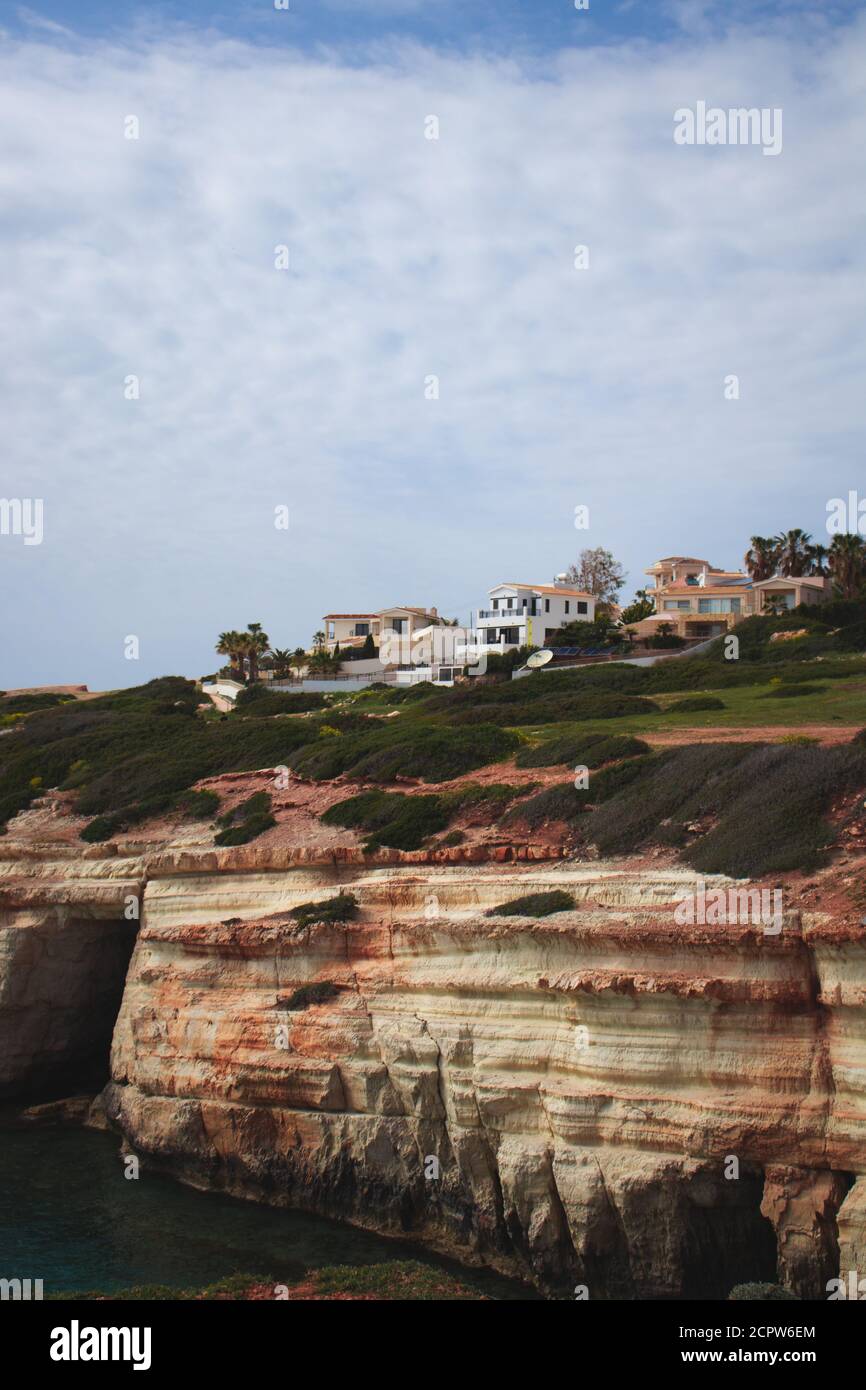 Cyprus, Mediterranean sea, Sea Caves, Rocky Coast with a city above Stock Photo