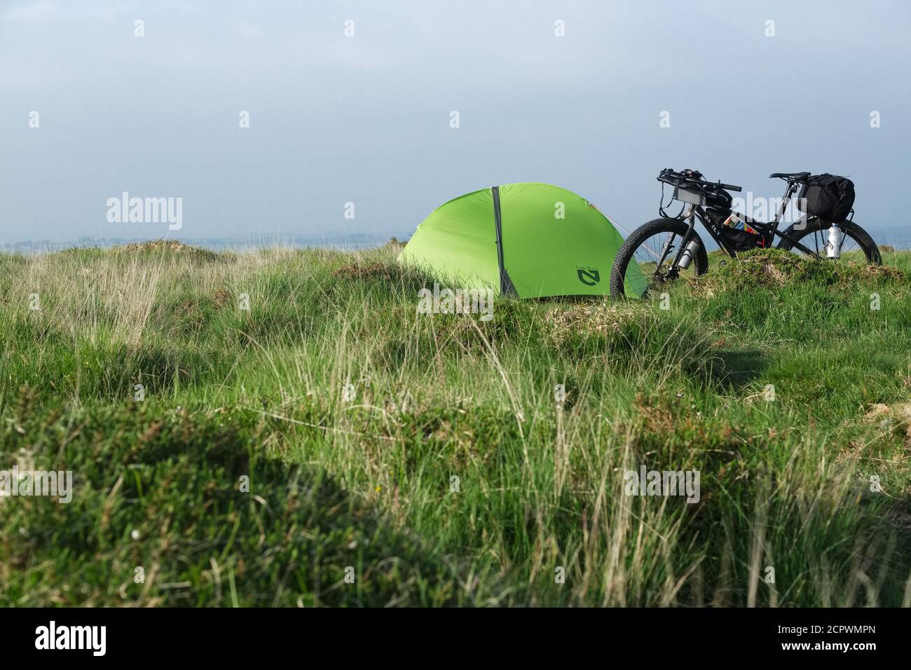 Bikepacking on Dartmoor. Wild camping, tent with a bicycle. Stock Photo