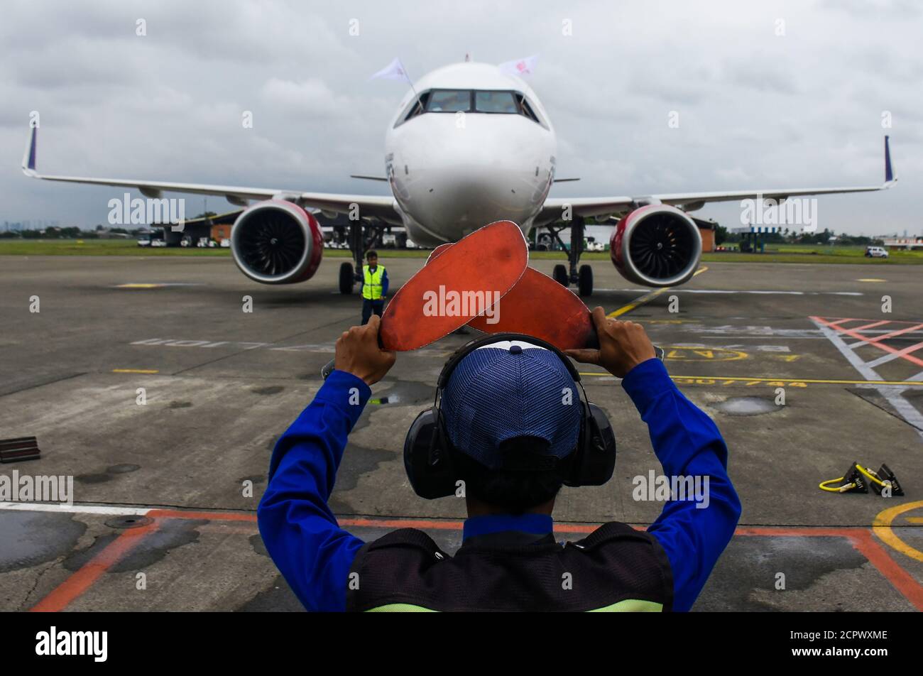 Indonesia, Tangerang-February 6, 2020: Marshaller command the Airbus A320 Neo aircraft when it arrives at Soekarno-Hatta airport Stock Photo