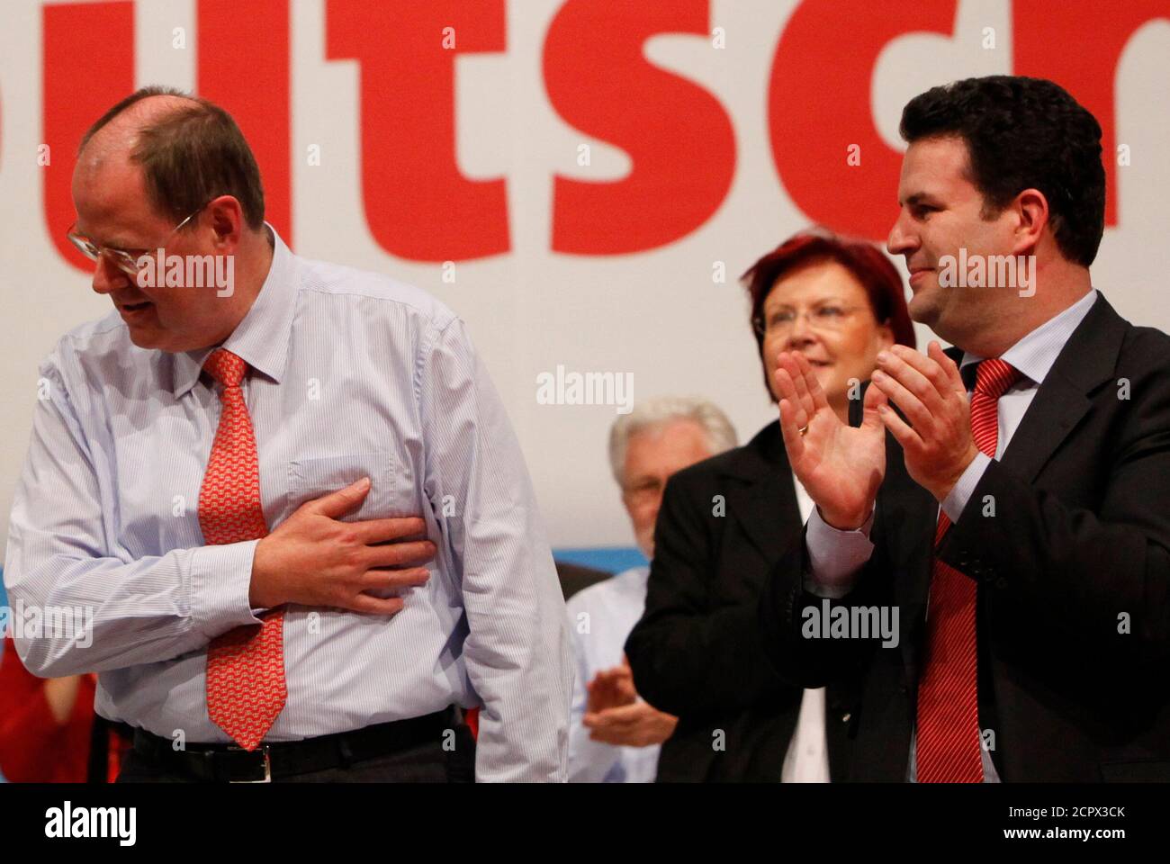 Leading SPD members Hubertus Heil (R) and Brigitte Zypris (2nd R) bid farewell to Peer Steinbrueck after he was relieved from his party office, at a party congress in Dresden, November 14, 2009. Germany's Social Democrats, knocked out of government in September, elected former environment minister Sigmar Gabriel as their seventh new leader in the last 10 years on Friday at a tense party congress. The painting shows former party leader, the late Willi Brandt.   REUTERS/Thomas Peter (GERMANY - Tags: POLITICS) Stock Photo