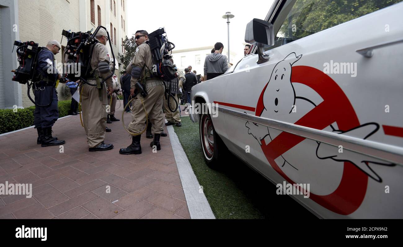 Enthusiasts wearing Ghostbusters costumes stand by an ECTO-1, the vehicle used in the upcoming movie 'Ghostbusters,' during a photo call at Sony Studios in Culver City, California March 2, 2016.    REUTERS/Mario Anzuoni Stock Photo