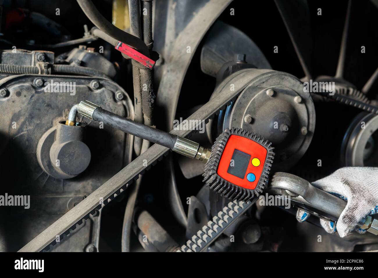 A car mechanic pumps out used oil from the engine. Hand with the device close-up Stock Photo