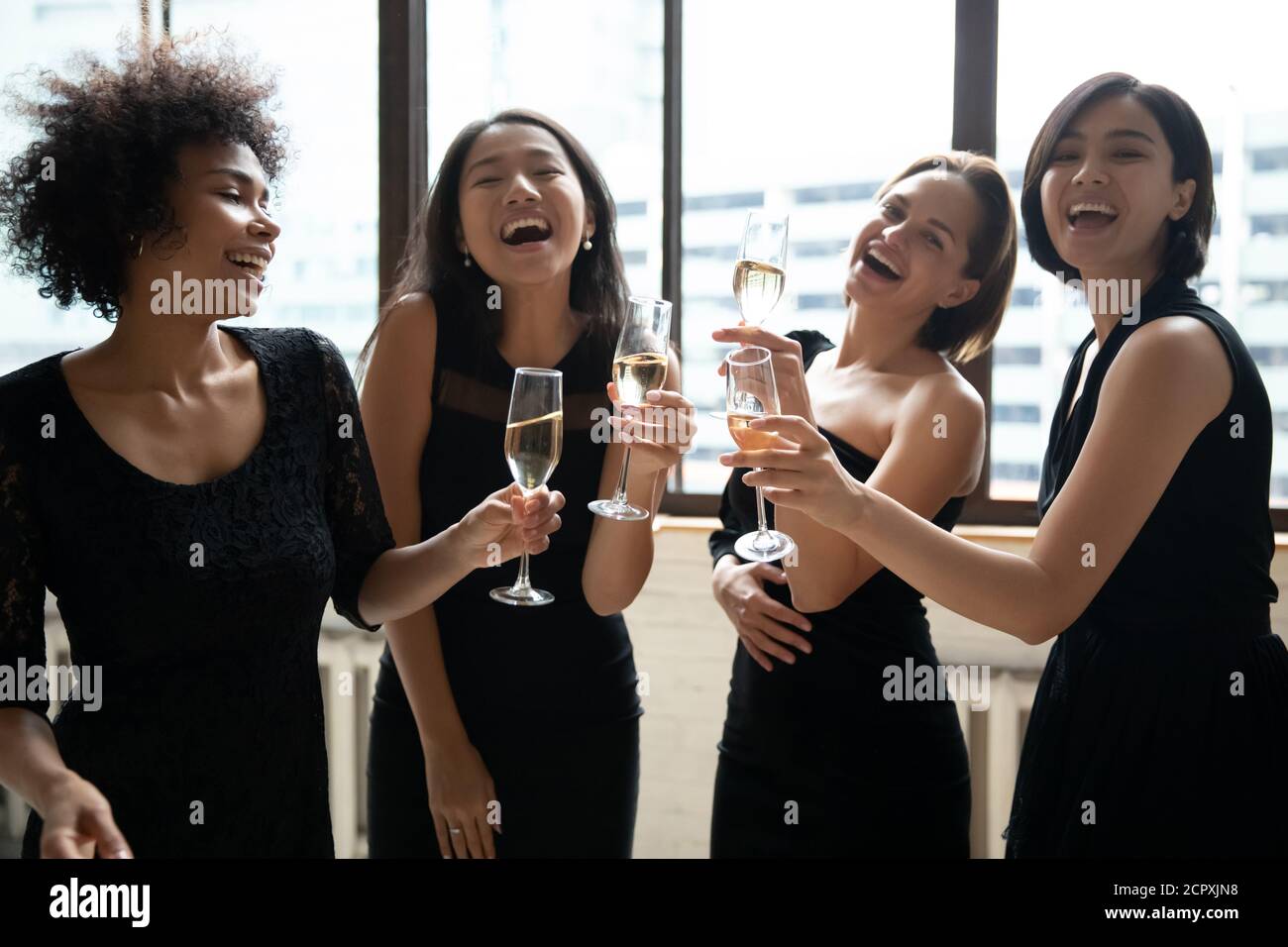 Overjoyed pretty ladies in black dresses enjoying party time. Stock Photo