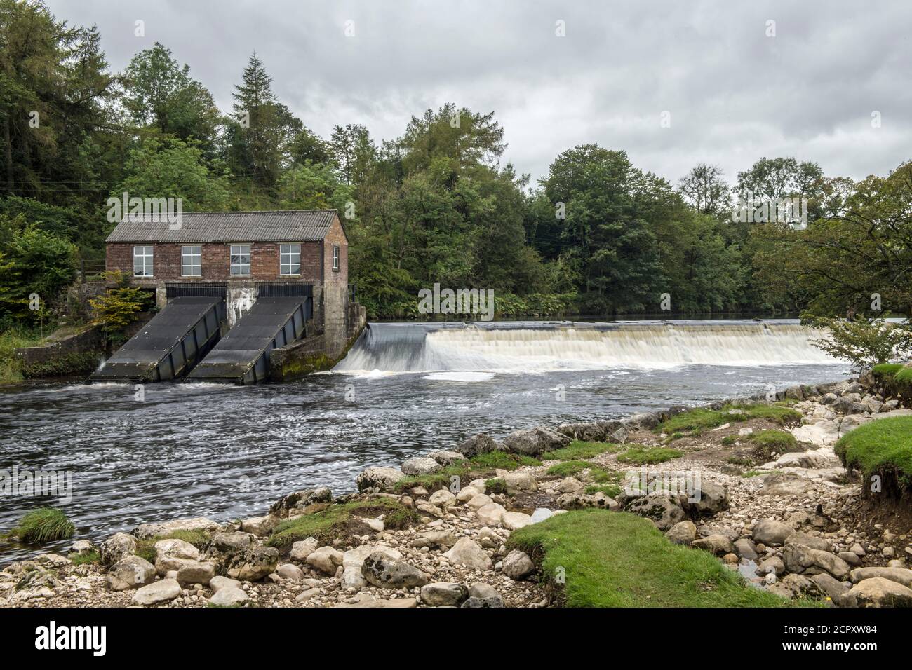 Upper weir on River Wharfe near Grassington with small hydro power station in the Yorkshire Dales National Park. Just above Linton Falls. Stock Photo