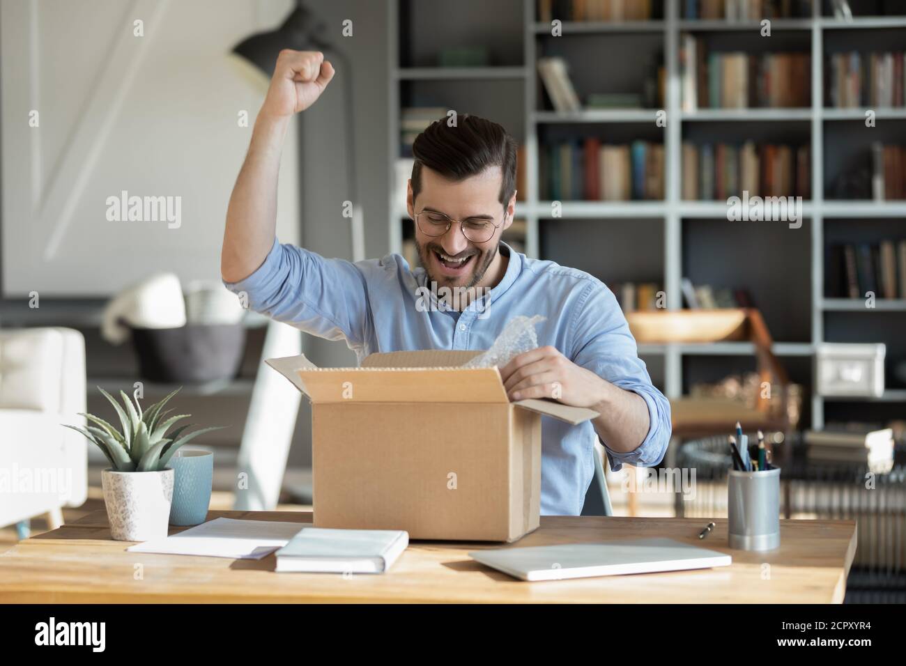 Overjoyed male buyer unbox internet order at home Stock Photo
