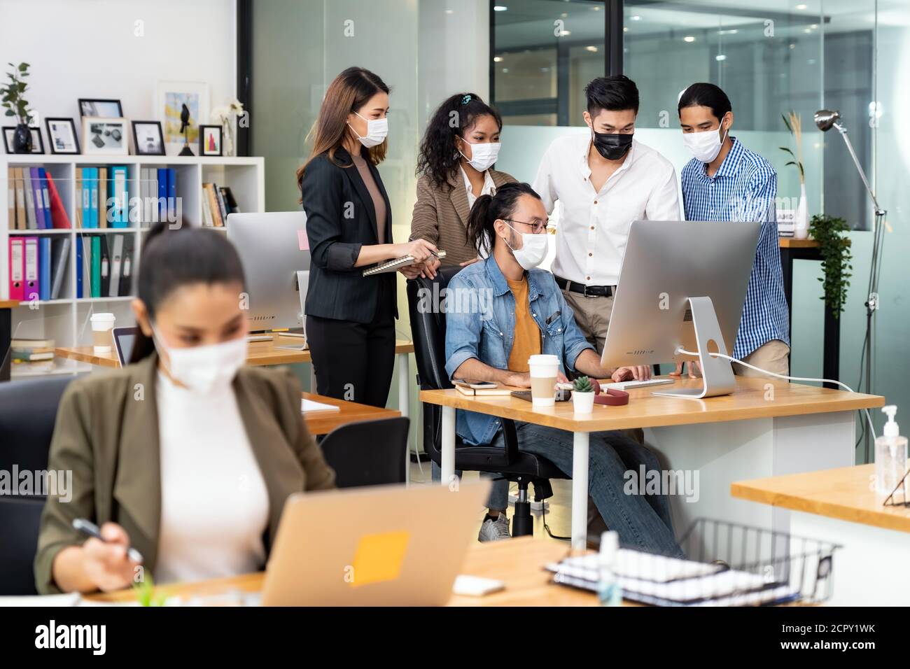 Group portrait of interracial business worker team wear protective face mask in new normal office with social distance practice prevent coronavirus CO Stock Photo