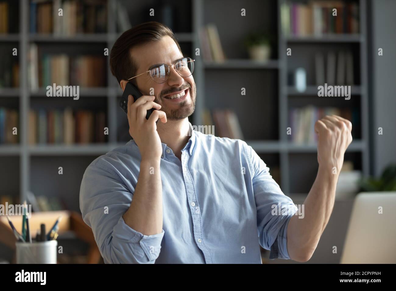 Excited man feel euphoric having good news on cellphone Stock Photo