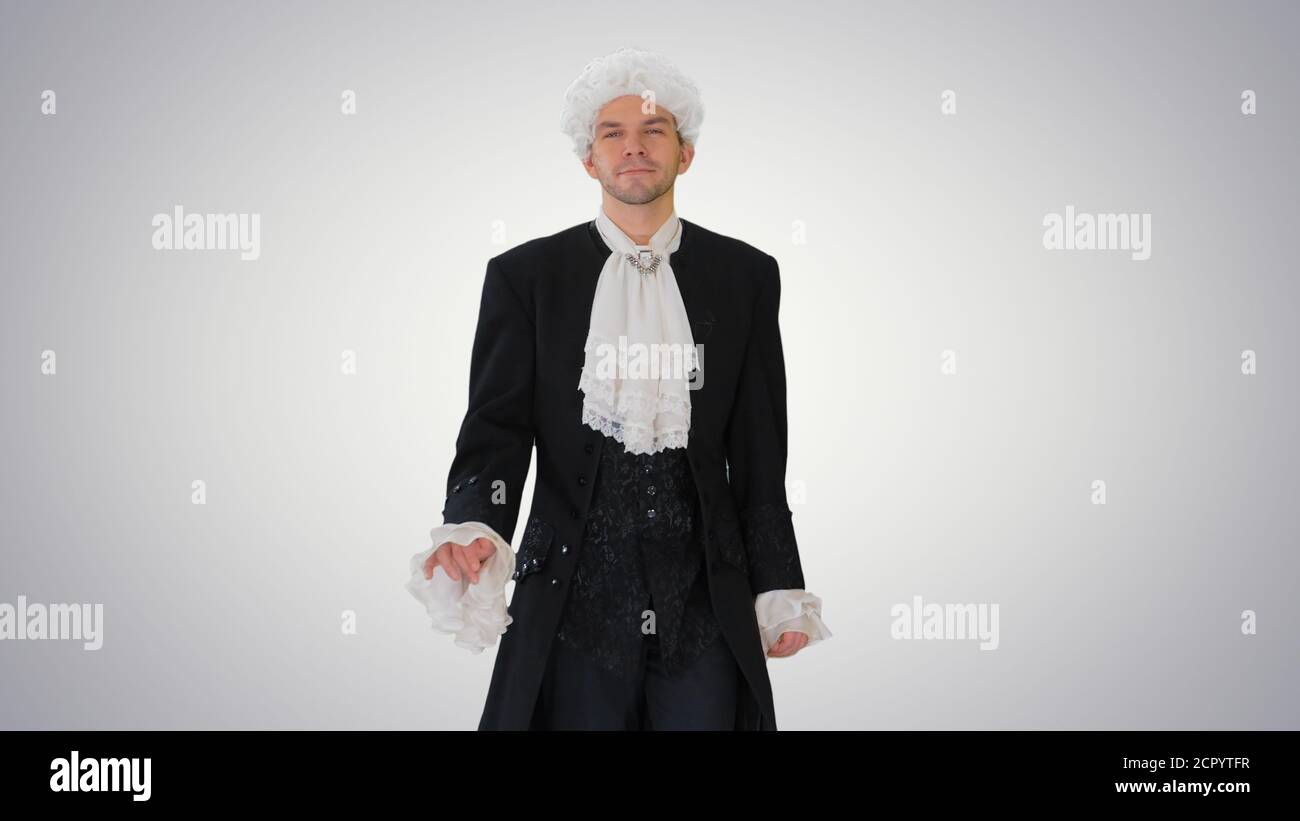 Man in old-fashioned laced frock coat and white wig walking in a Stock Photo