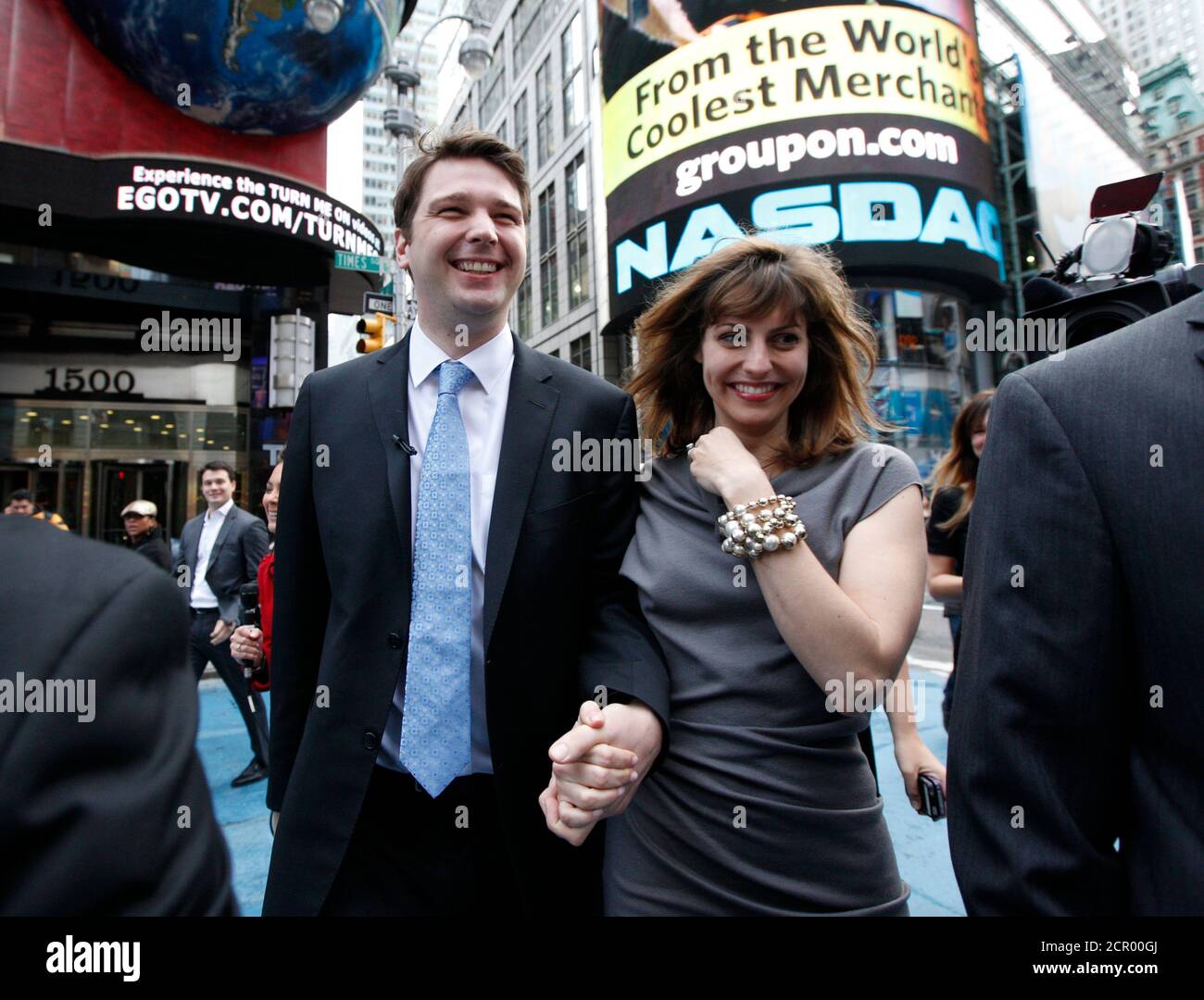 Groupon Chief Executive Andrew Mason walks with his newly married wife, pop musician Jenny Gillespie, outside the Nasdaq Market following his company's IPO in New York November 4, 2011. Shares of daily deals site Groupon Inc rose 46 percent in hectic early trading on Friday. The shares were at $29.15 or 46 percent above their $20 IPO price a few minutes after opening on the Nasdaq. A spokeswoman for Groupon confirmed on August 22, 2011, that Mason and Gillespie are planning to marry in October, but would not specify a date.  REUTERS/Brendan McDermid (UNITED STATES - Tags: BUSINESS ENTERTAINMEN Stock Photo