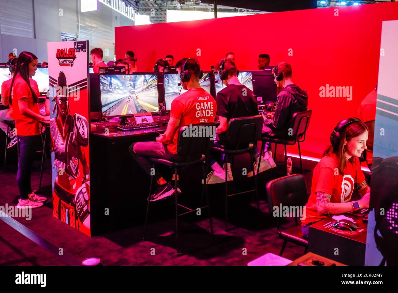 Visitors playing computer games in front of screens, trade fair for computer and video games Gamescom, Cologne, North Rhine-Westphalia, Germany Stock Photo