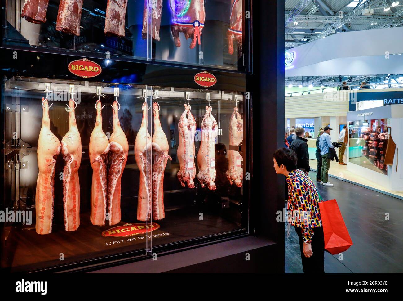 Trade fair visitors look at pork at the booth of the French meat company Bigard, ANUGA food fair, Cologne, North Rhine-Westphalia, Germany Stock Photo