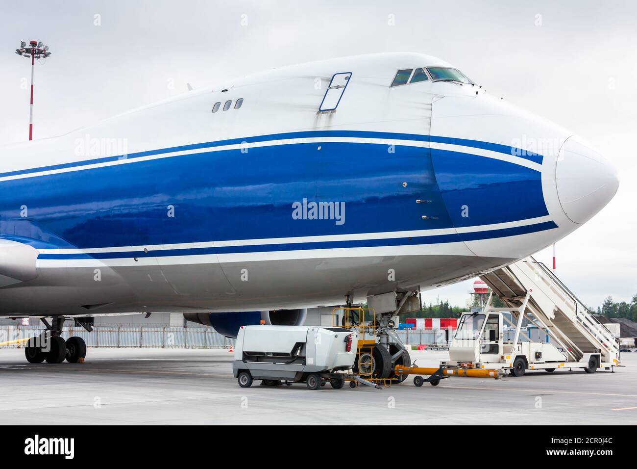 The front of widebody cargo airplane with towbar and passenger step ...