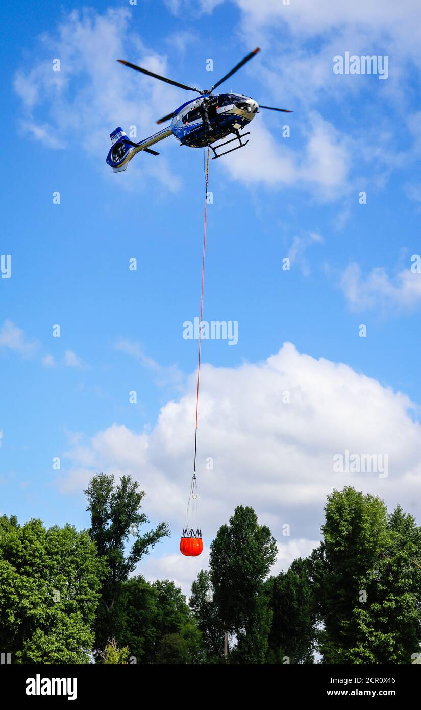 Airbus H 145 police helicopter during an operational exercise with the BAMBI BUCKET extinguishing water tank, Düsseldorf, North Rhine-Westphalia, Stock Photo