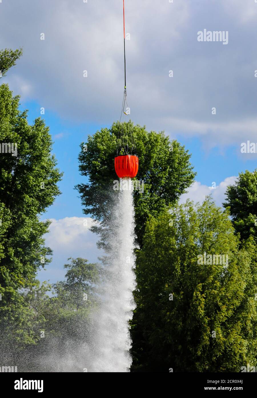 Police helicopter during an operational exercise with the BAMBI BUCKET extinguishing water tank, Düsseldorf, North Rhine-Westphalia, Germany Stock Photo