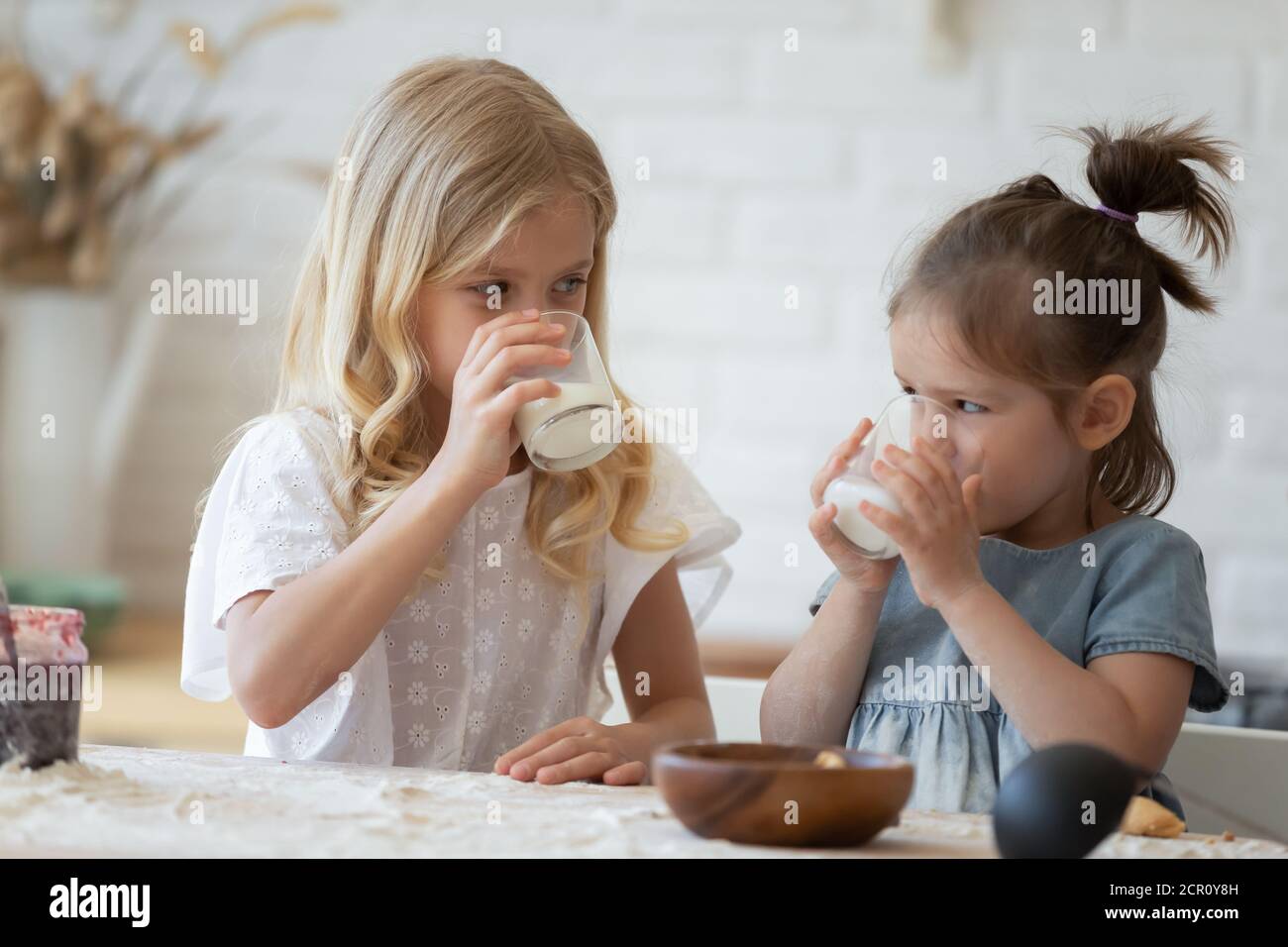 Girls drinking milk from glasses Stock Photo