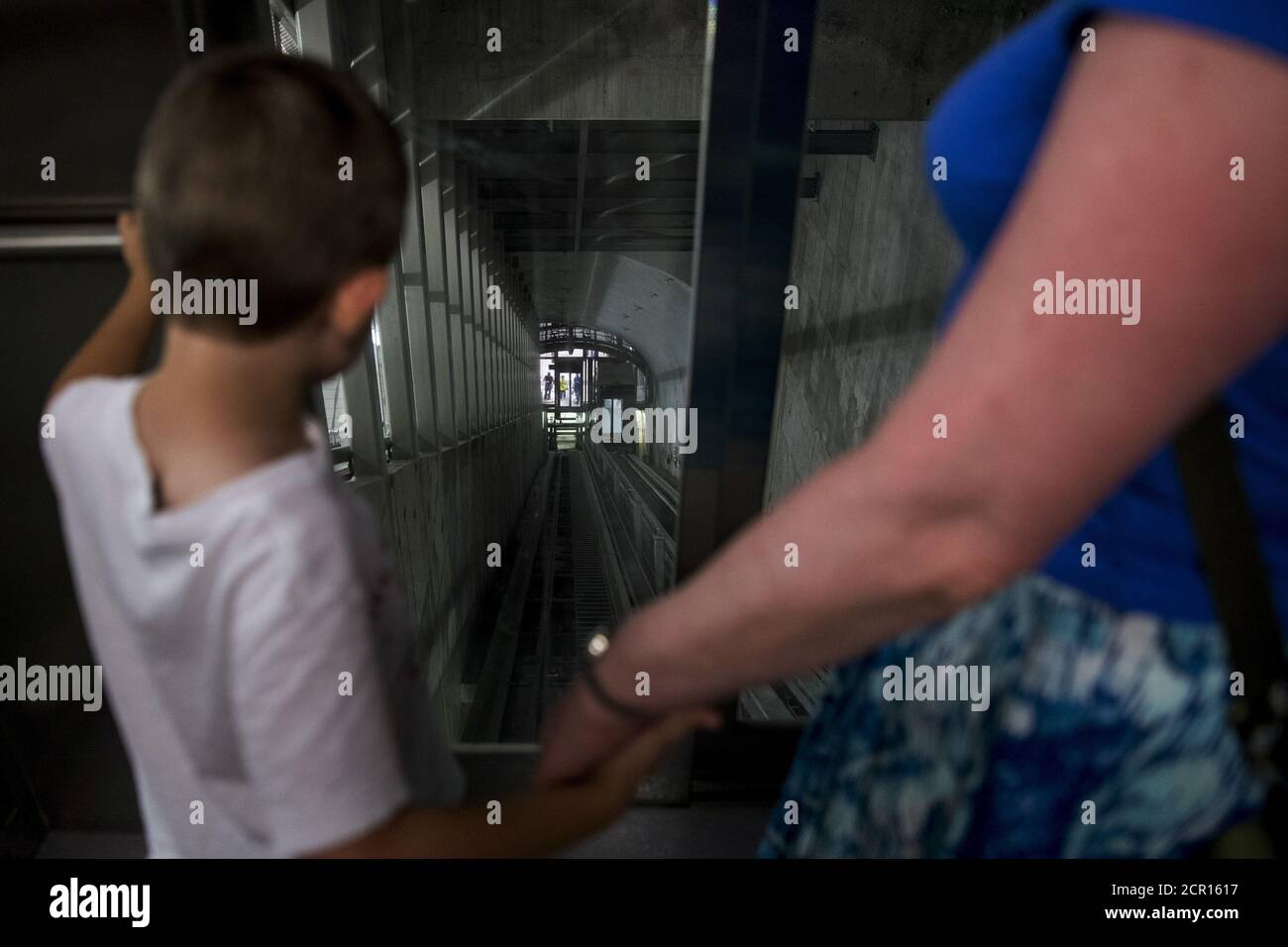A young passenger looks ahead into the elevator shaft as he rides the inclined elevator at the new 34th St./Hudson Yards subway station in midtown Manhattan, New York, September 13, 2015. After eight years and $2.42 billion, the 34th Street and 11th Avenue stop on New York's 7 train line has opened, featuring the longest escalator and first inclined elevator on the city's subway system.   REUTERS/Brendan McDermid Stock Photo