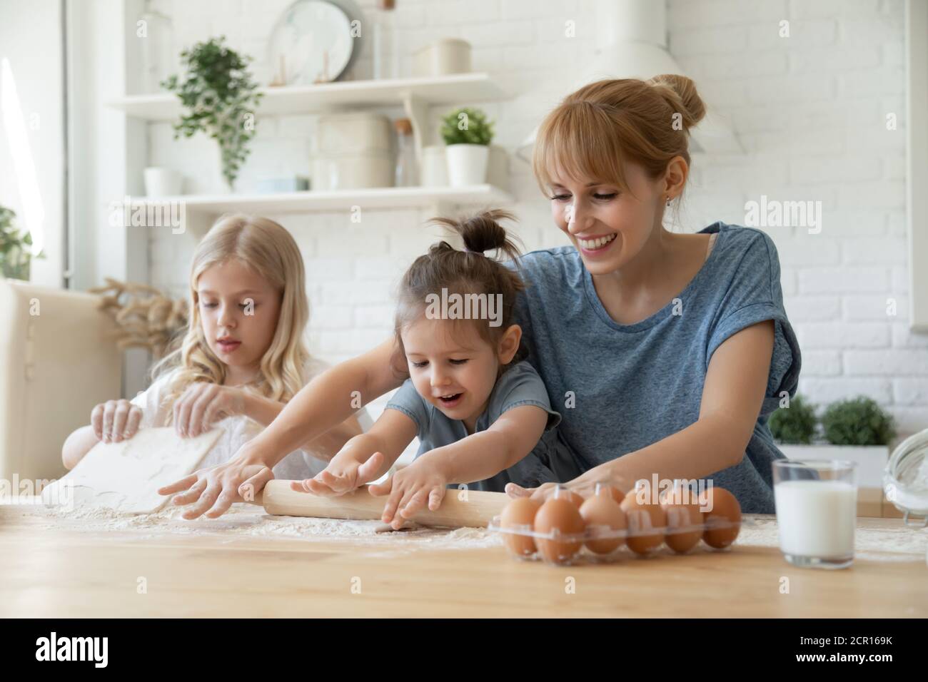 Mum and kids are making cookies together Stock Photo