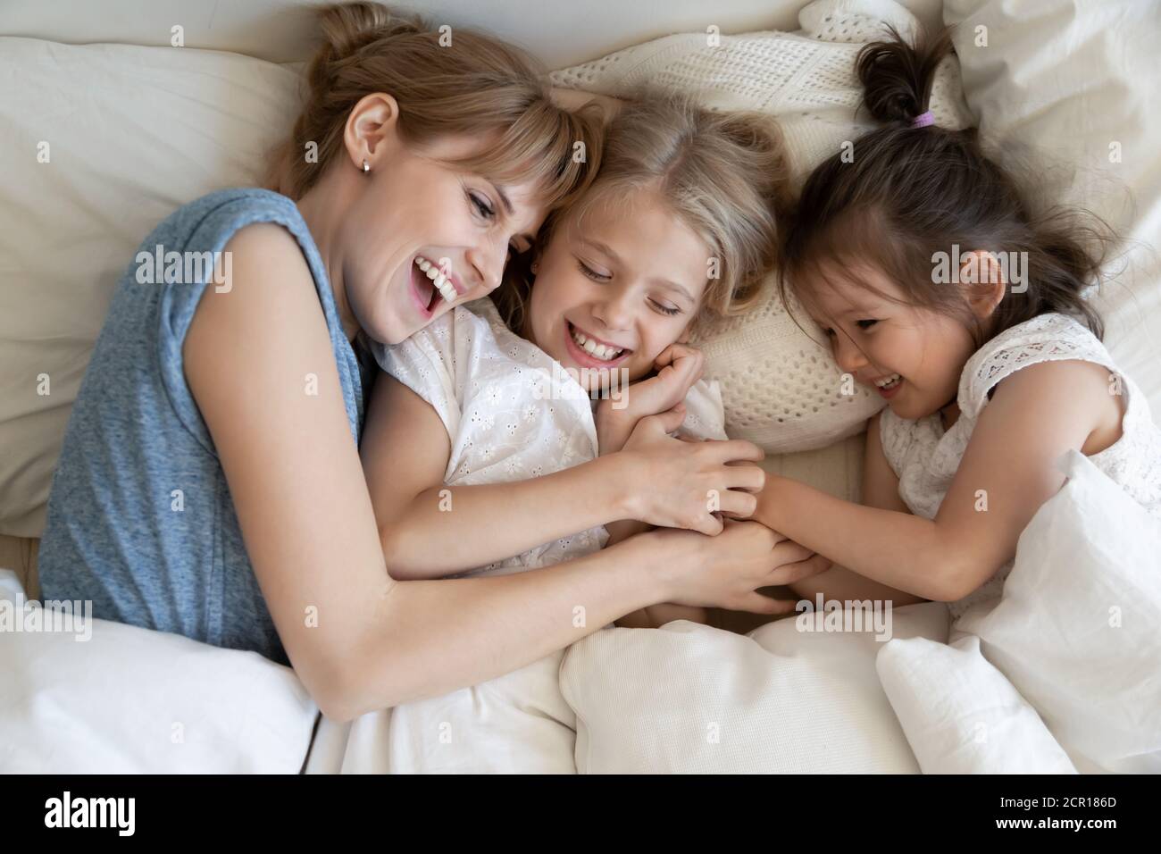 Mum and kids cuddling in bed Stock Photo