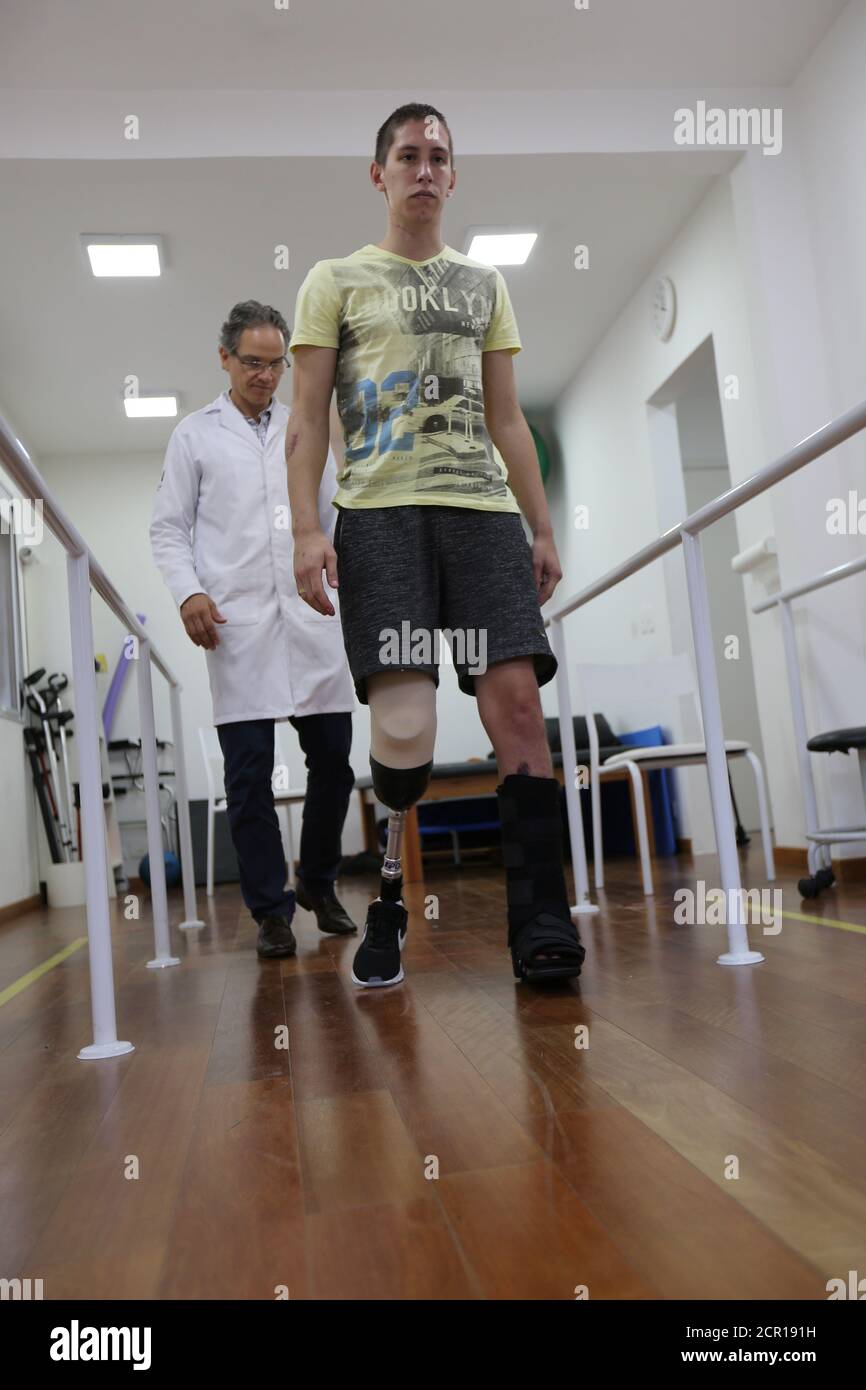 Goalkeeper Jackson Follmann (R), who survived when the plane carrying Brazilian soccer team Chapecoense crashed, walks next to Dr. Jose Carvalho as he tries on a prosthetic leg in Sao Paulo, Brazil, February 21, 2017. REUTERS/Paulo Whitaker Stock Photo